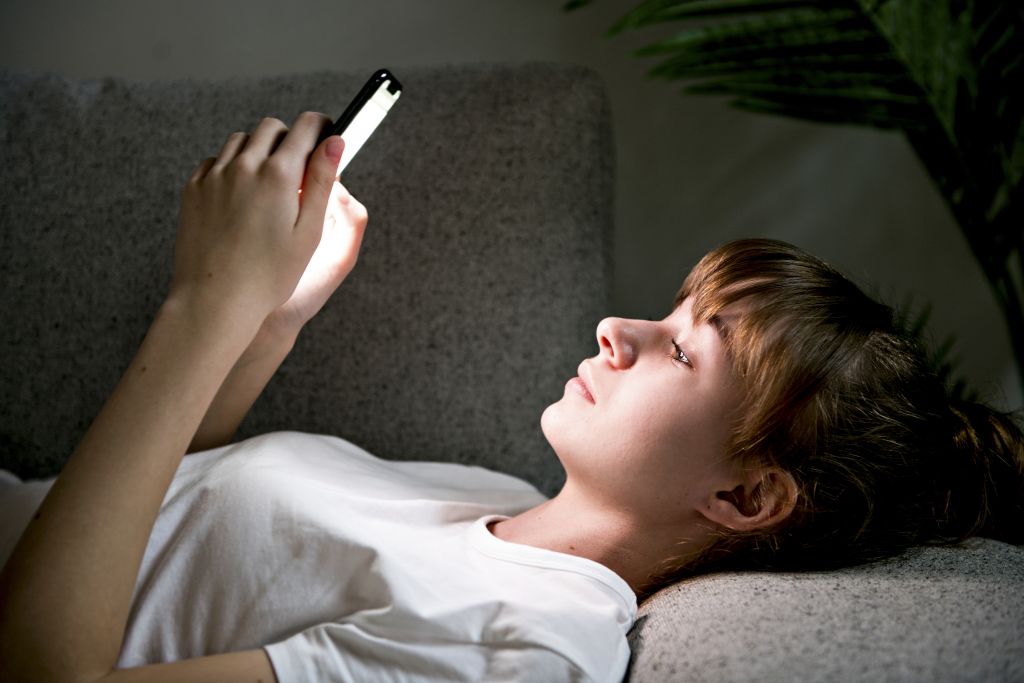 Teen Girl Holds Phone Sitting On Sofa Young Woman Looking At Cell Feeling Hopeless