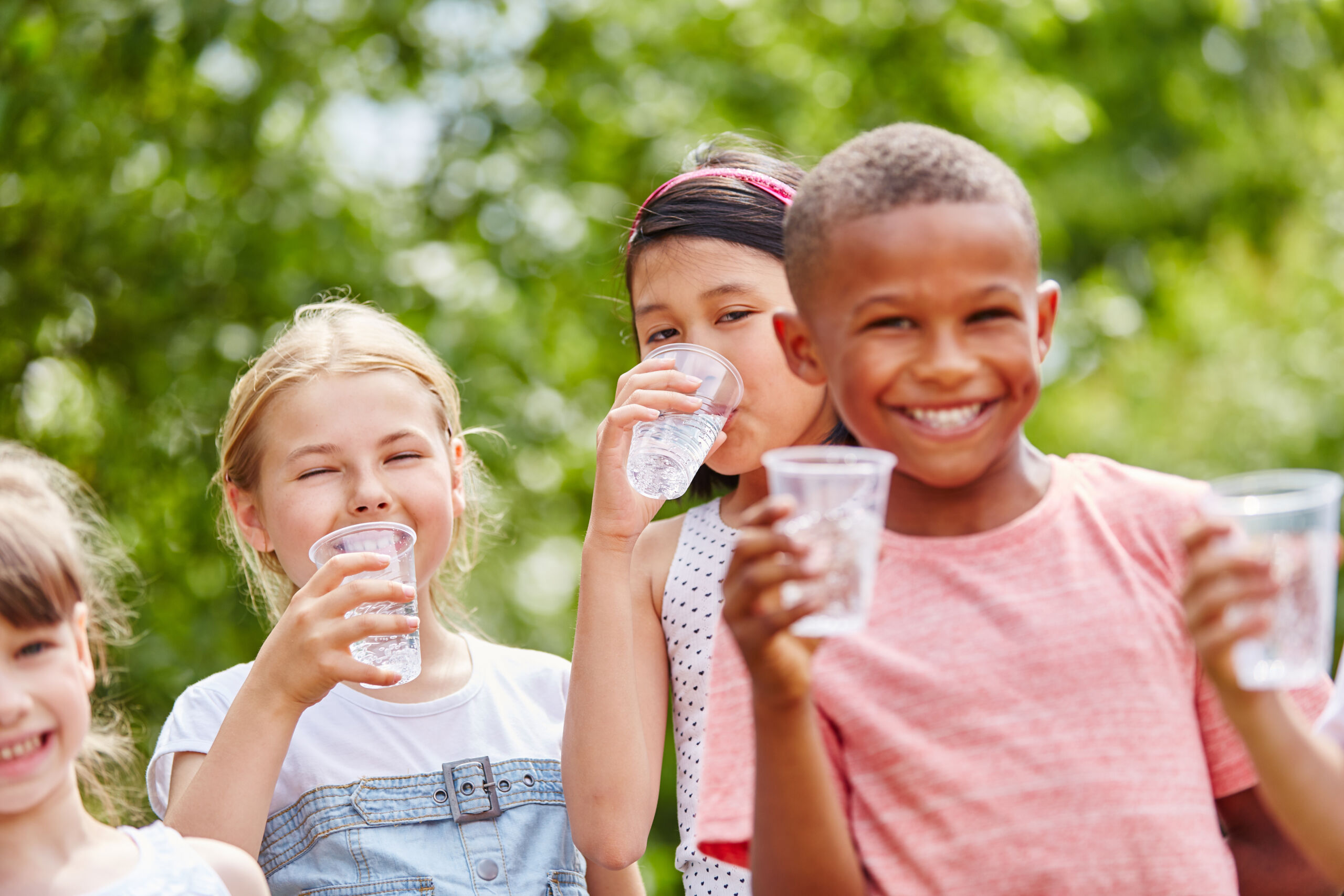 kinder mit plastikbechern trinkt wasser