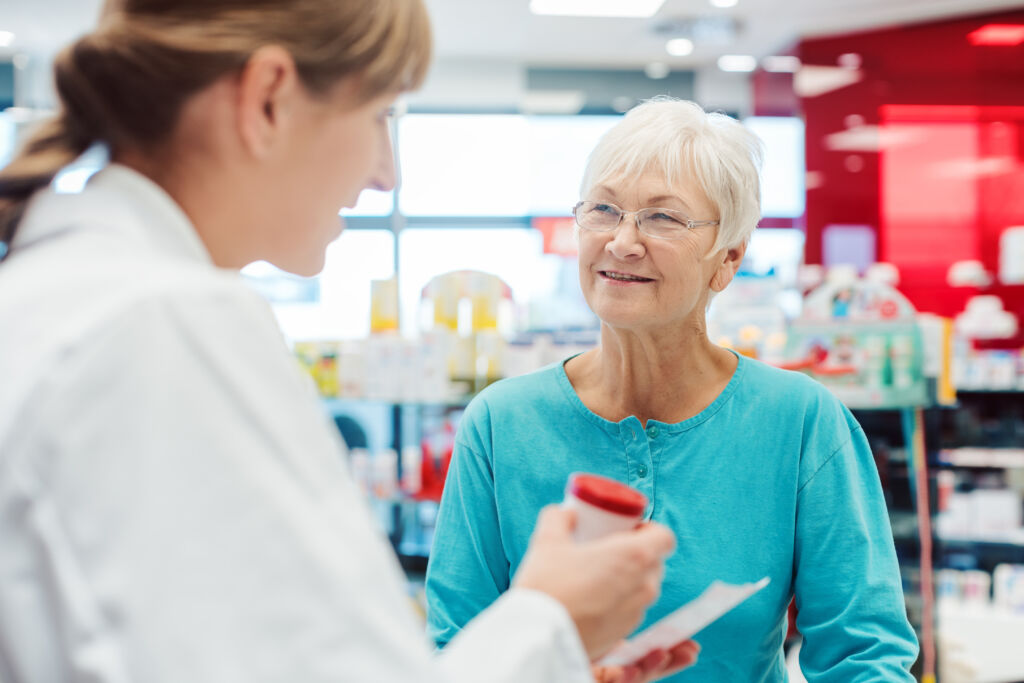 senior woman in pharmacy talking to the chemist or pharmacist