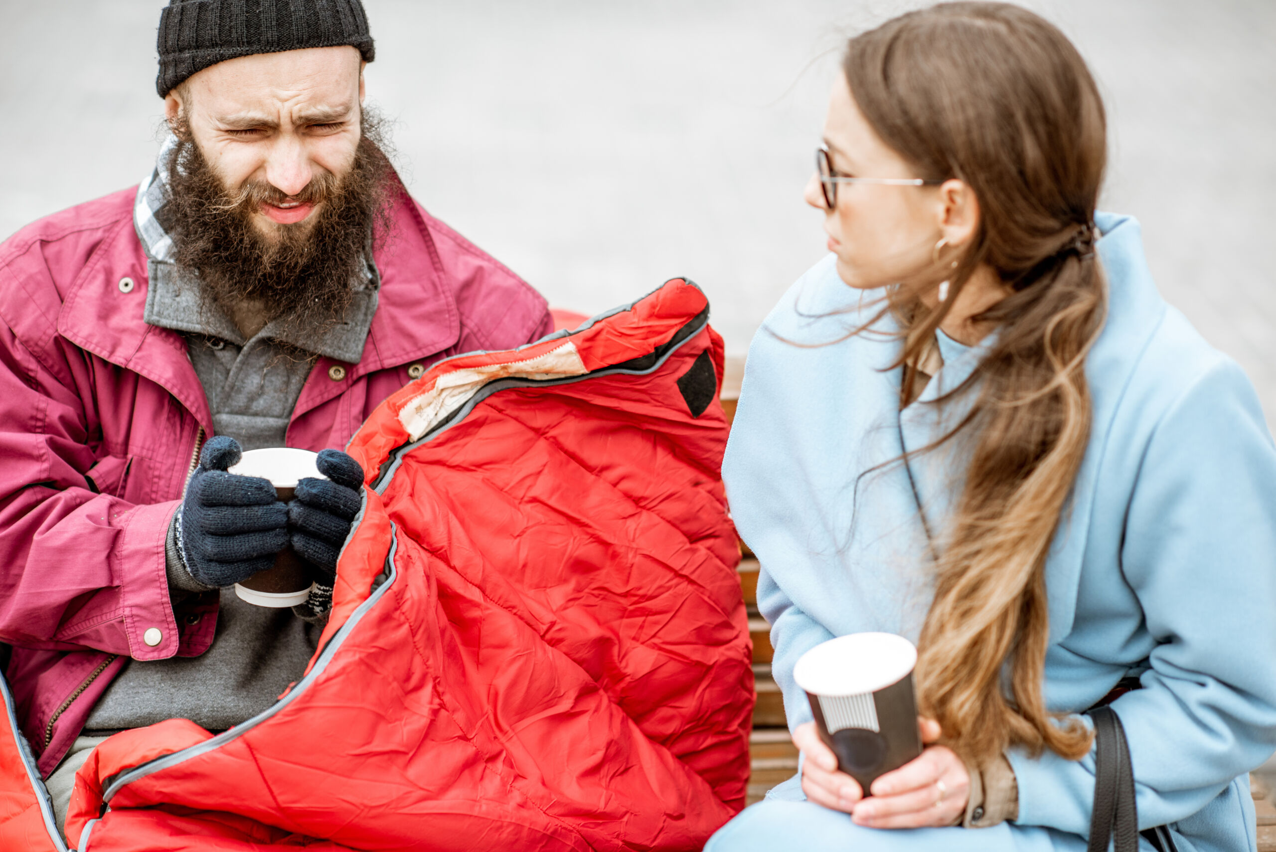 homeless beggar with young woman listening to his story