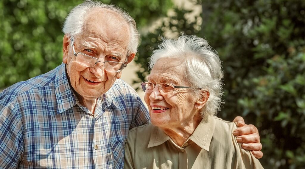 elderly couple standing together outside