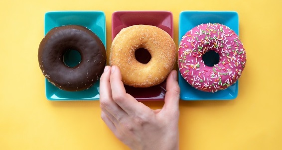 three different donuts, on a plate on yellow background