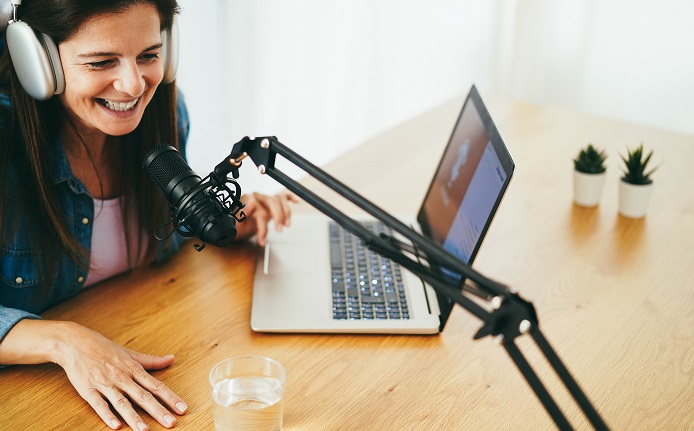 mature woman live streaming podcast session at home studio focus on microphone