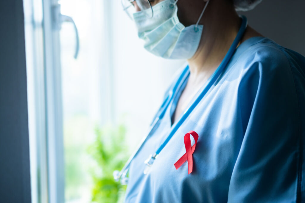 female doctor with red ribbon profile view looking out window